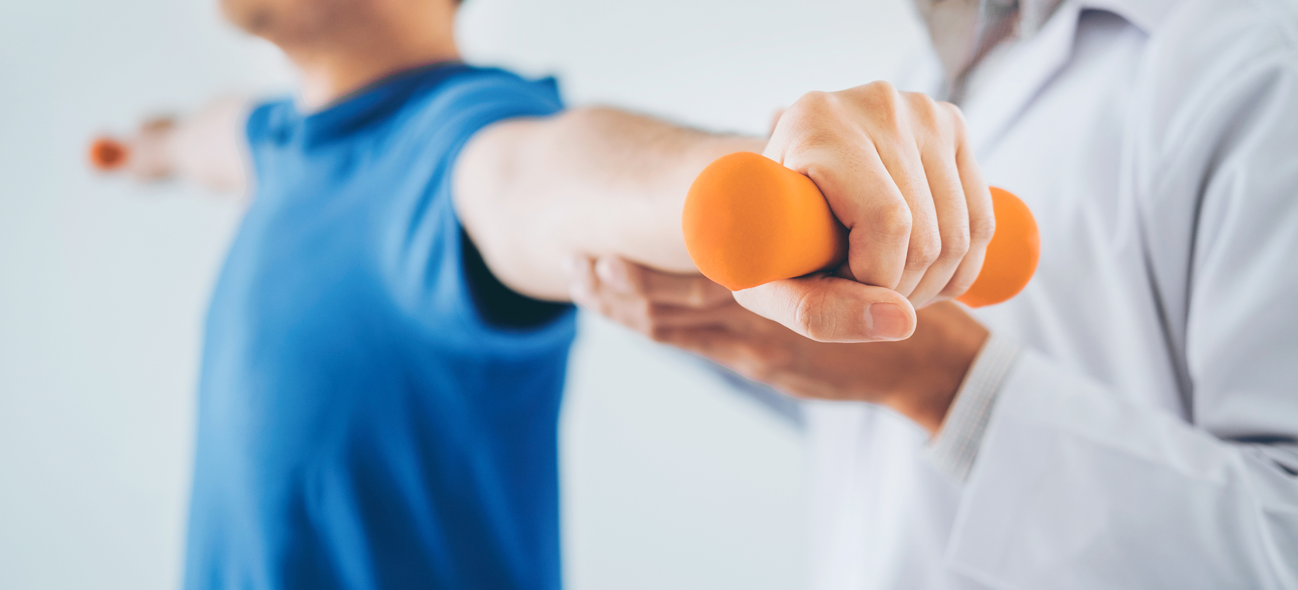 Physiotherapist man giving exercise with dumbbell treatment About Arm and Shoulder of athlete male patient Physical therapy concept